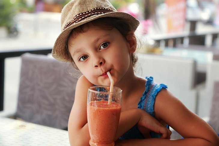 resilient child drinks from orange smoothie after being raised properly